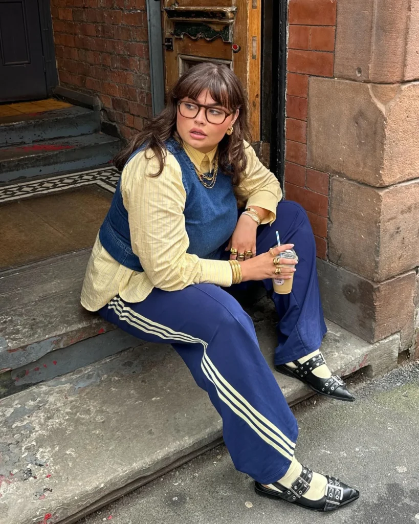 Mulher jovem de pele clara e cabelo castanho. ela usa look esportivo casual e sapatilha